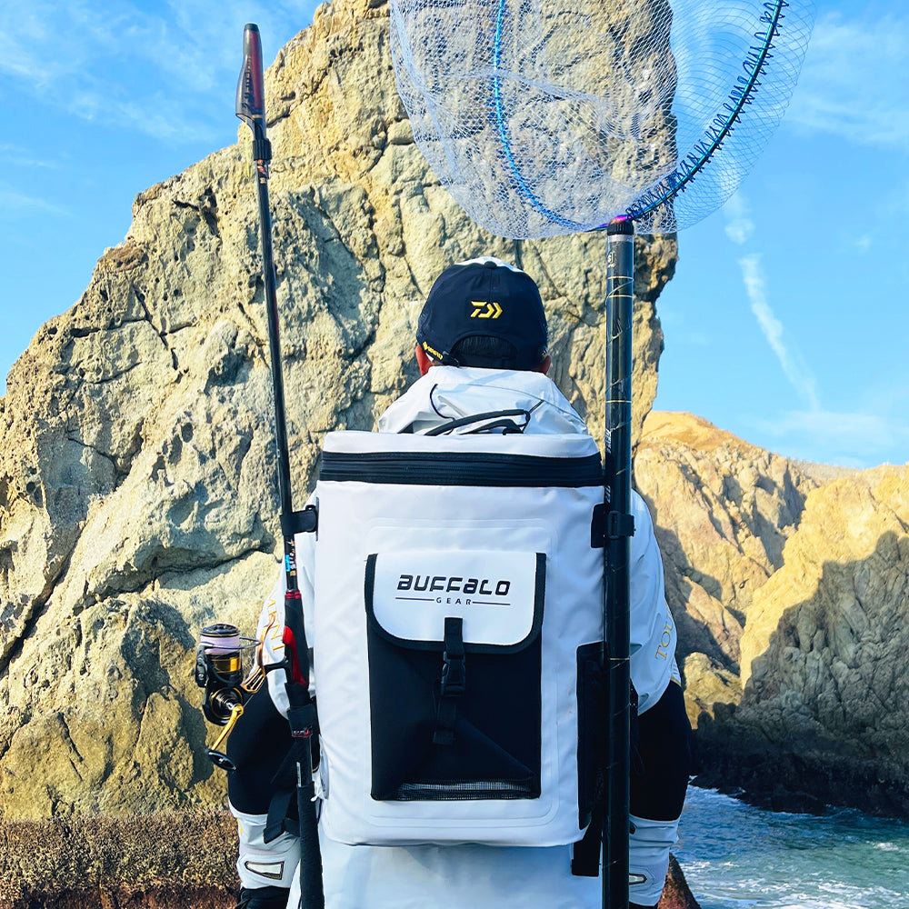 Person with a backpack labeled 'Buffalo' by a rocky coastline