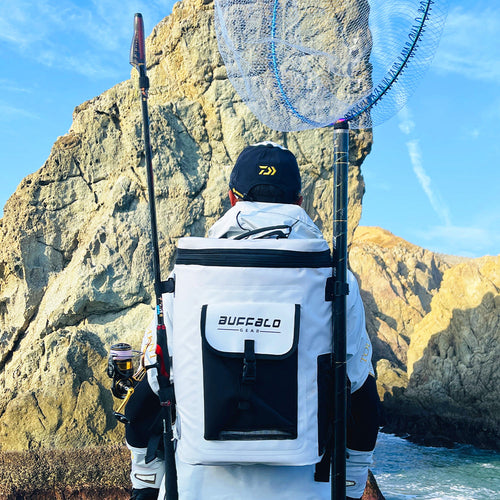 Person with a backpack labeled 'Buffalo' by a rocky coastline