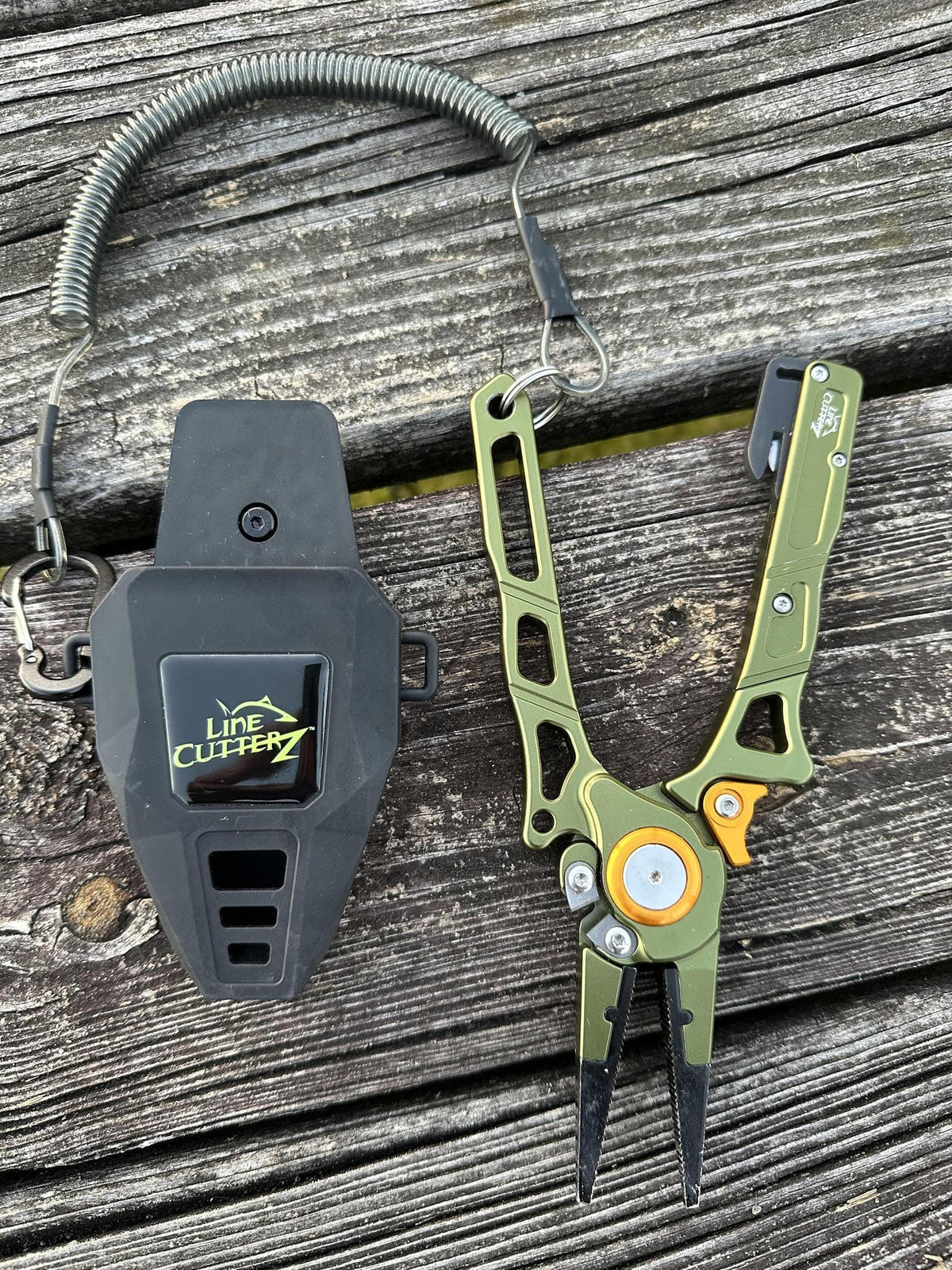 Fishing pliers and line cutter on a wooden surface