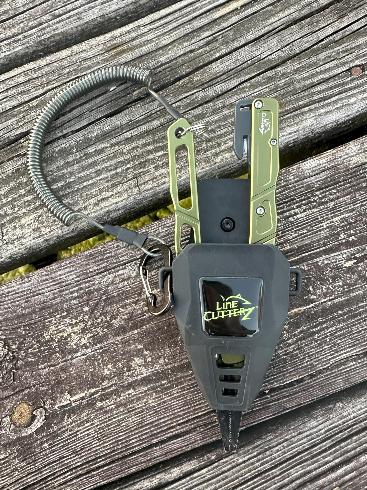 Green and gray line cutter on a wooden surface