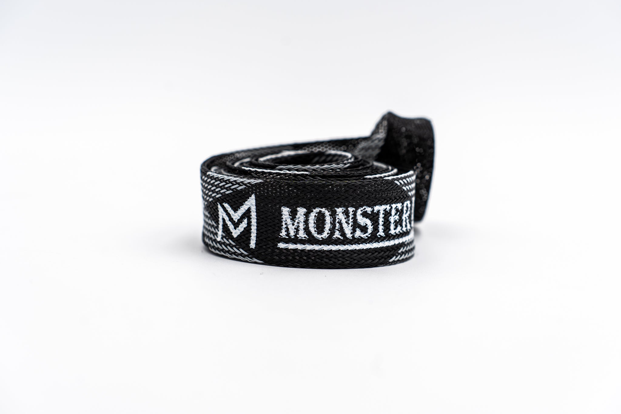 Black and white Monster branded belt on a white background