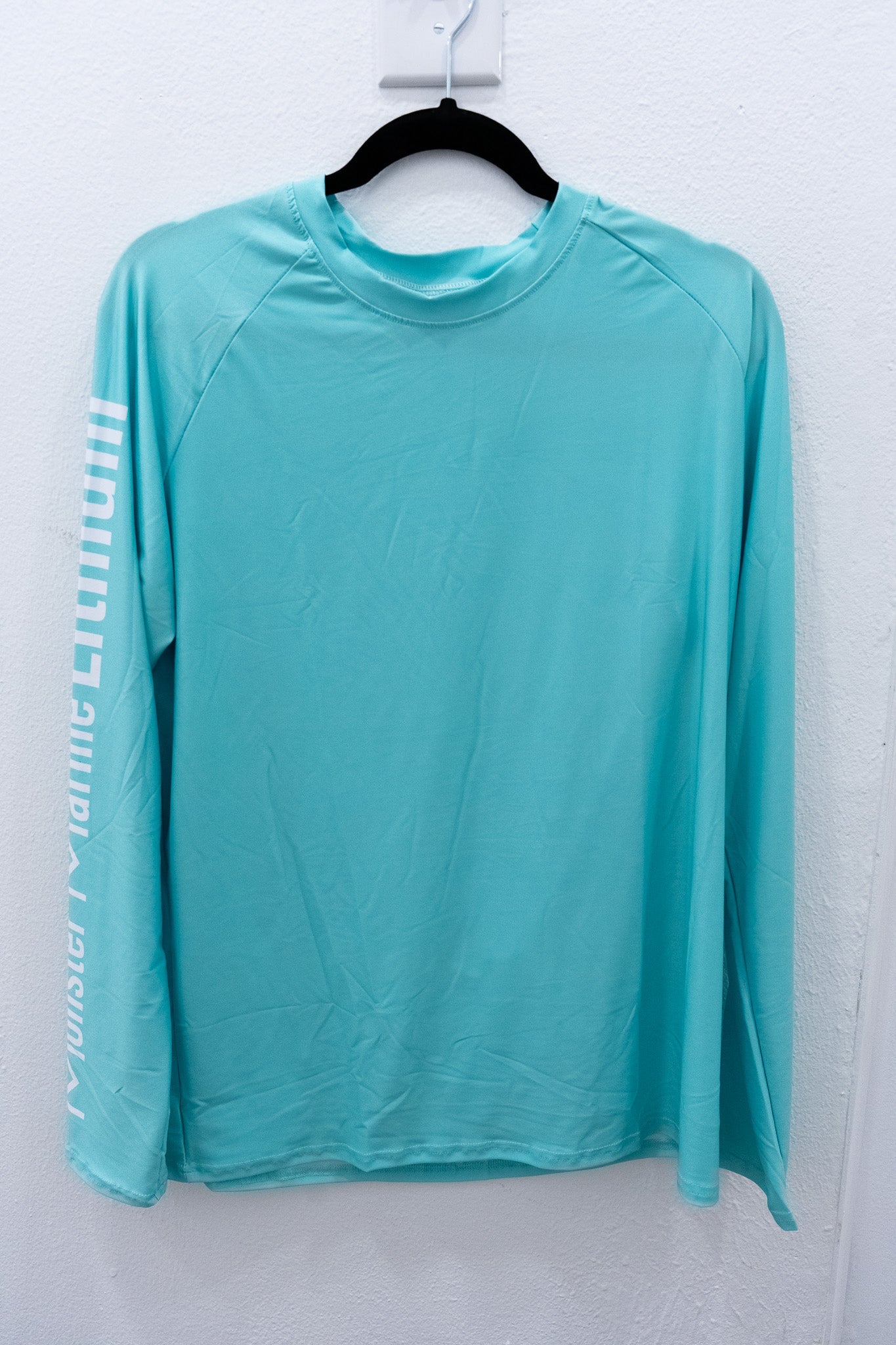 Turquoise long-sleeve shirt on a hanger against a white background
