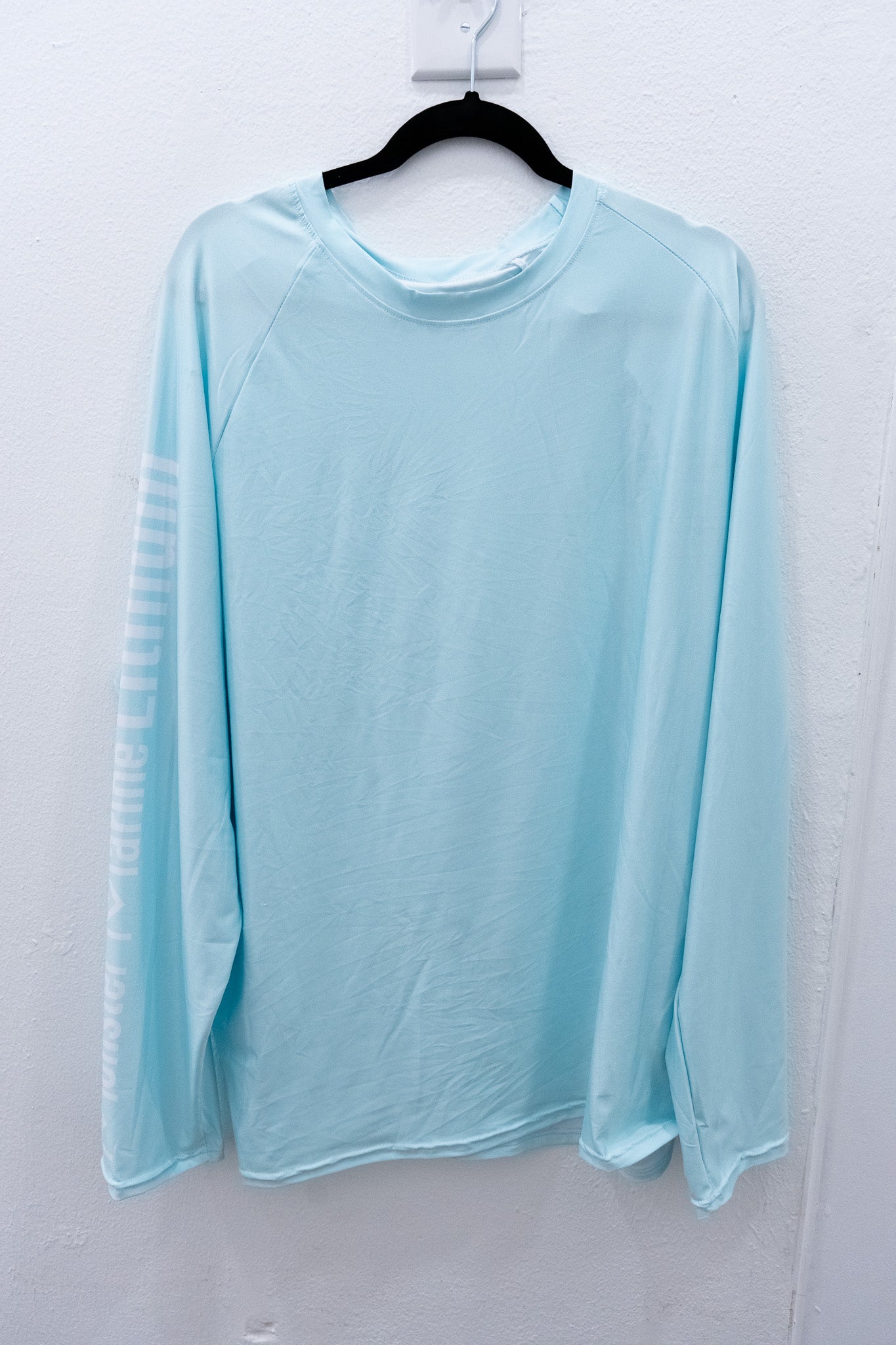Light blue long-sleeve shirt on a hanger against a white background