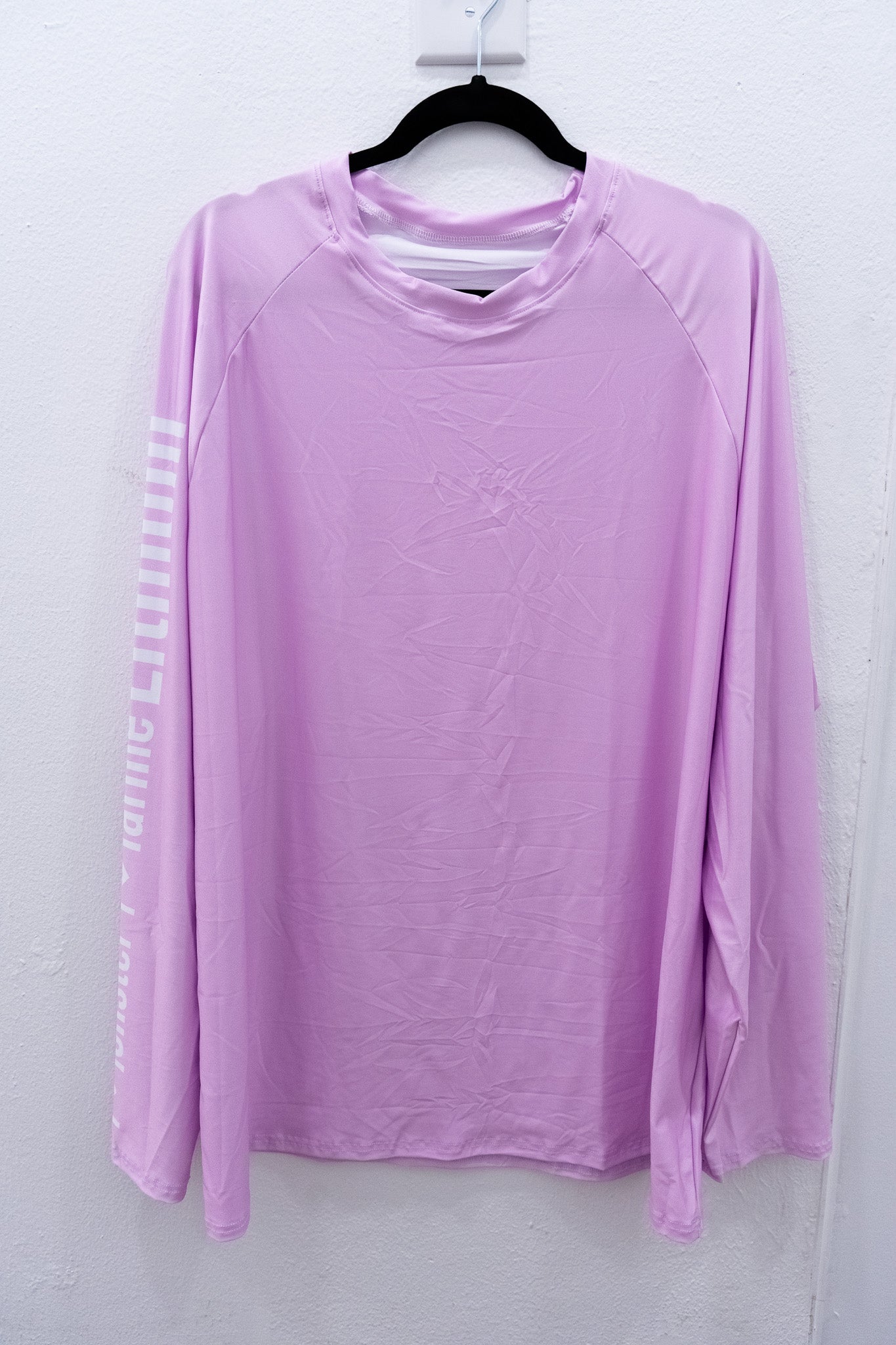 Purple long-sleeve shirt on a hanger against a white background