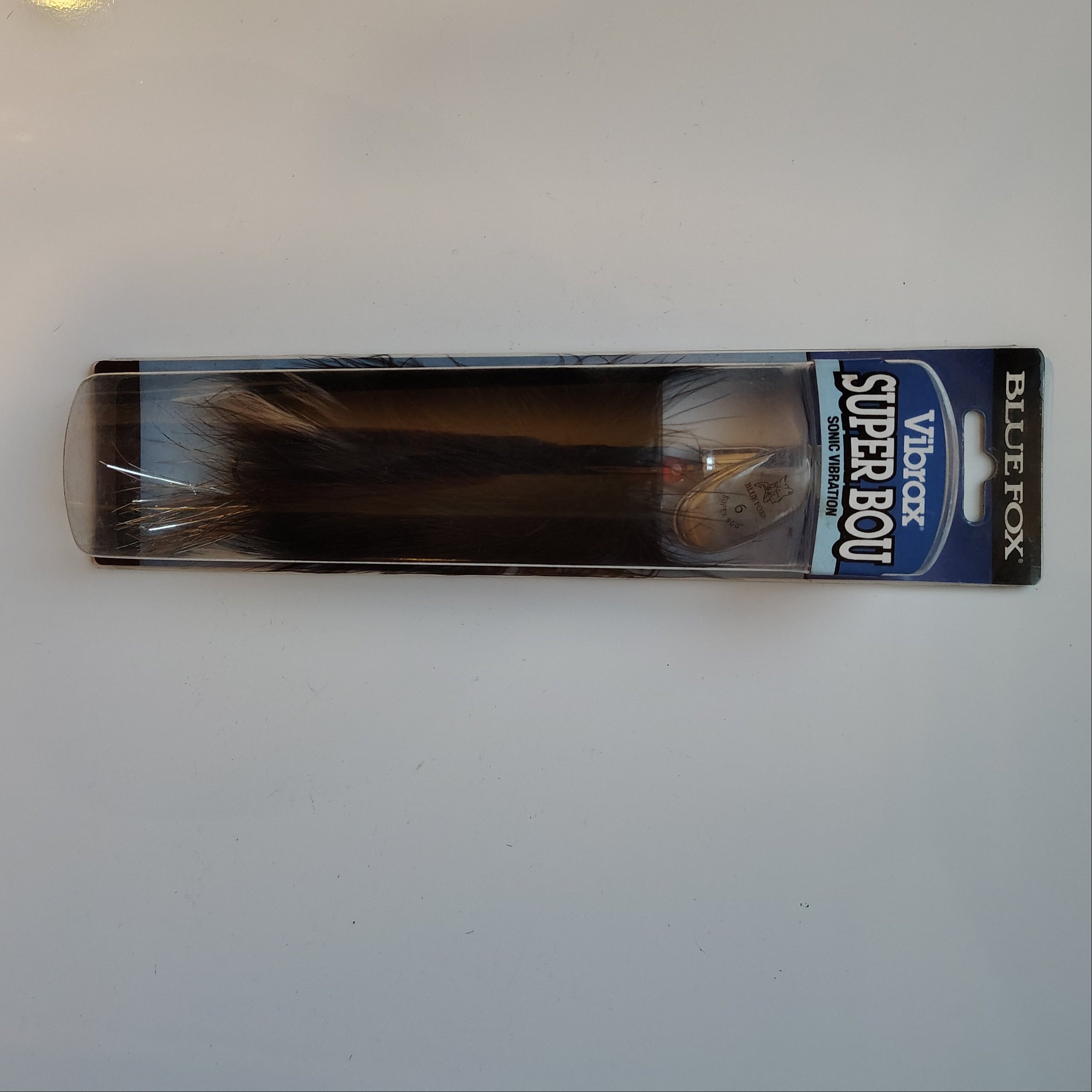 Packaged fishing lure on a white surface