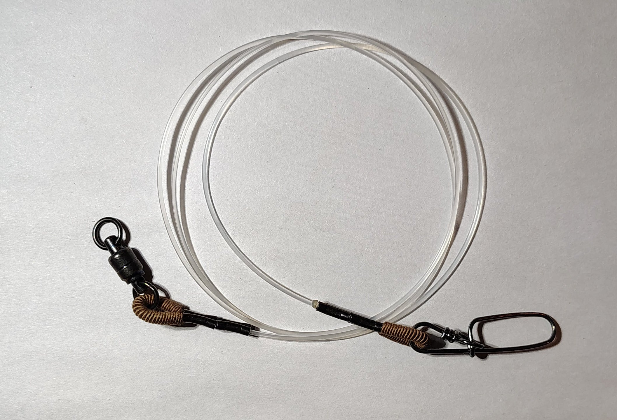 Fishing tackle including a spool of line and a package on a white surface