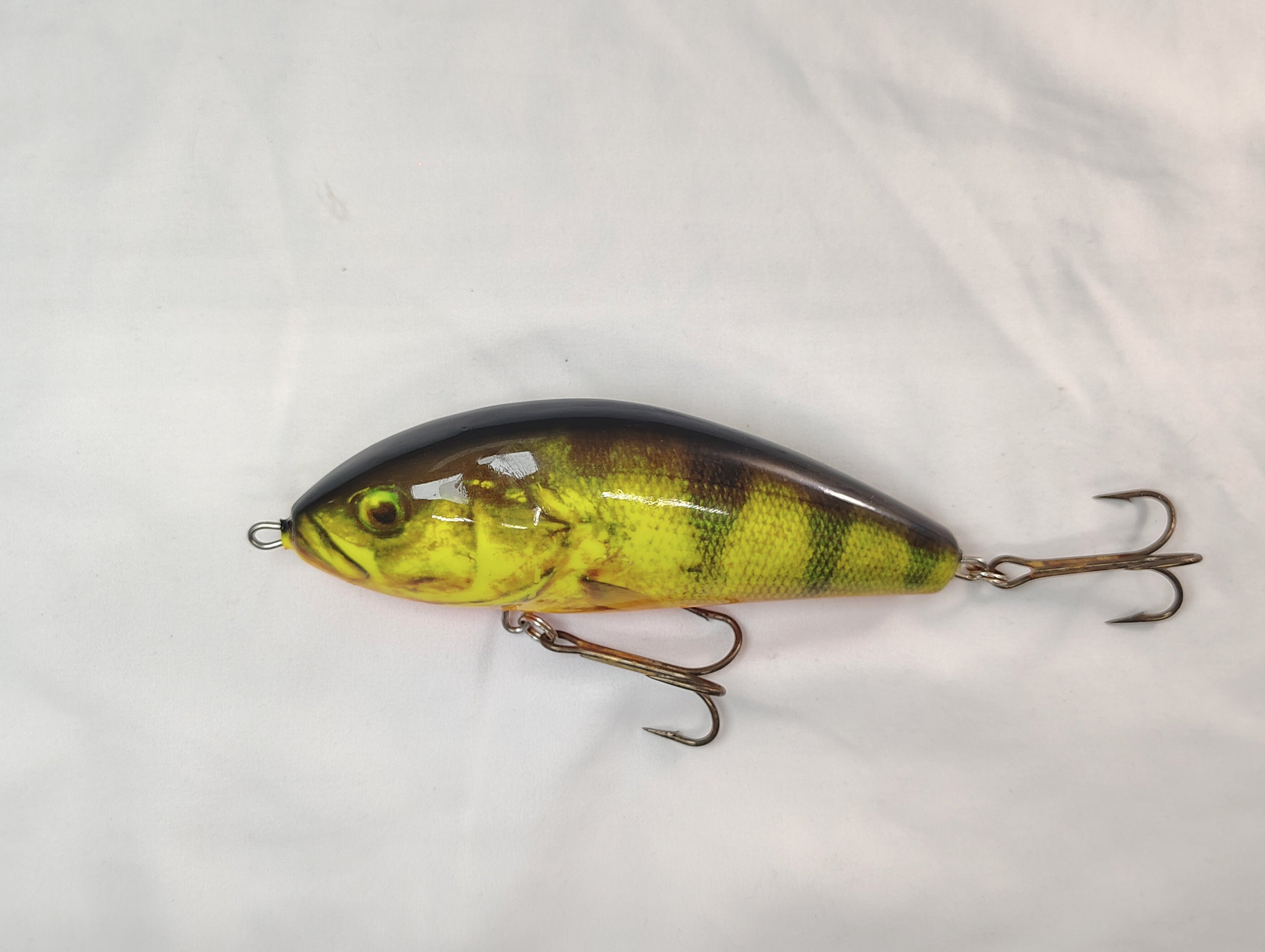 Fishing lure with a green and black pattern on a white background