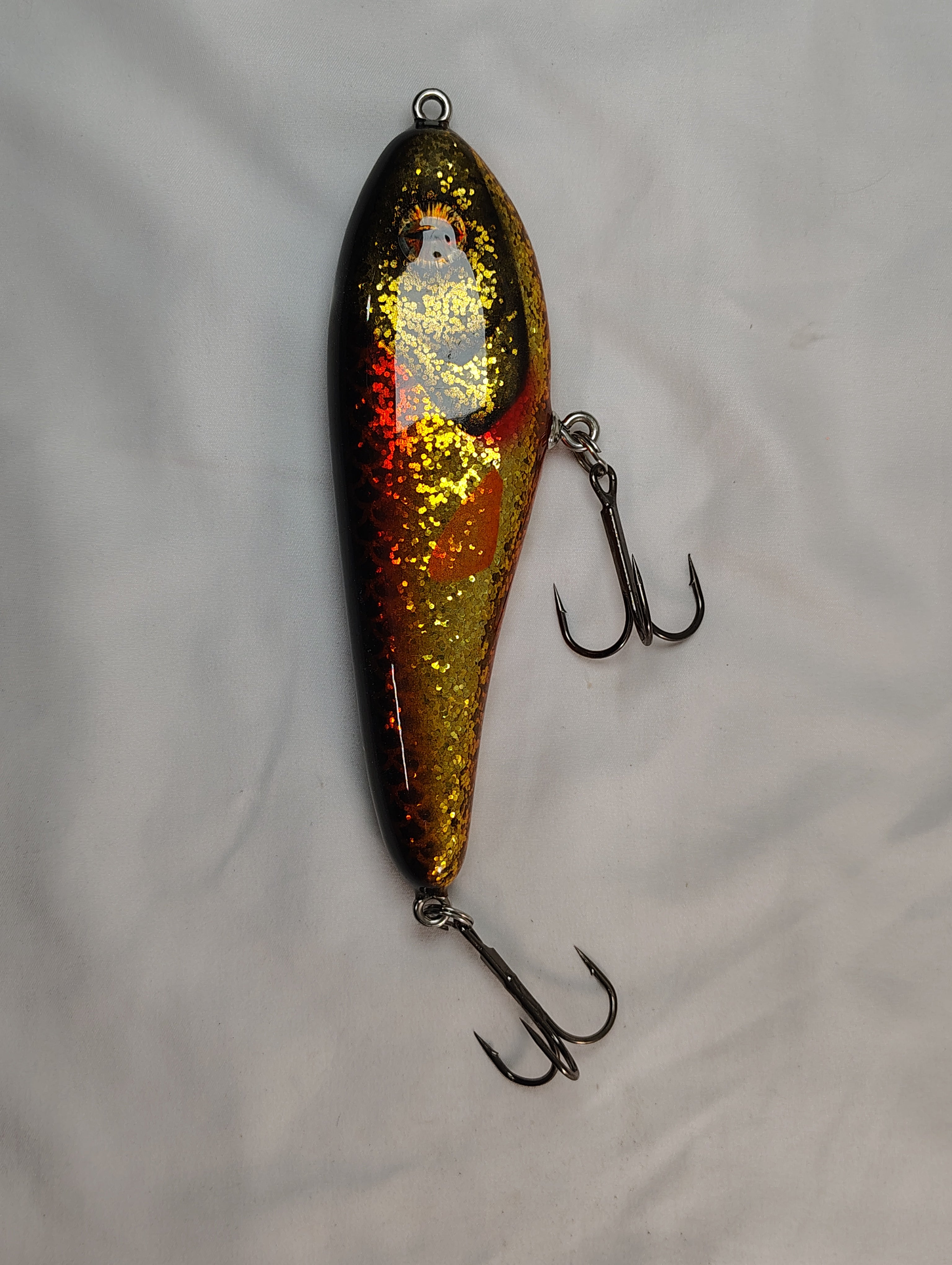 Fishing lure with a glittery finish on a white background