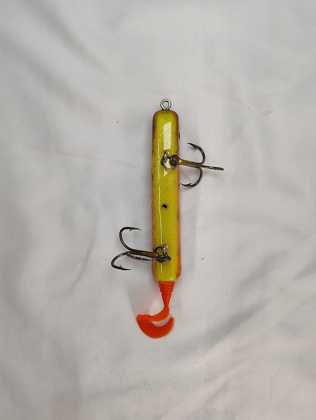 Yellow and orange fishing lure with multiple hooks on a white background