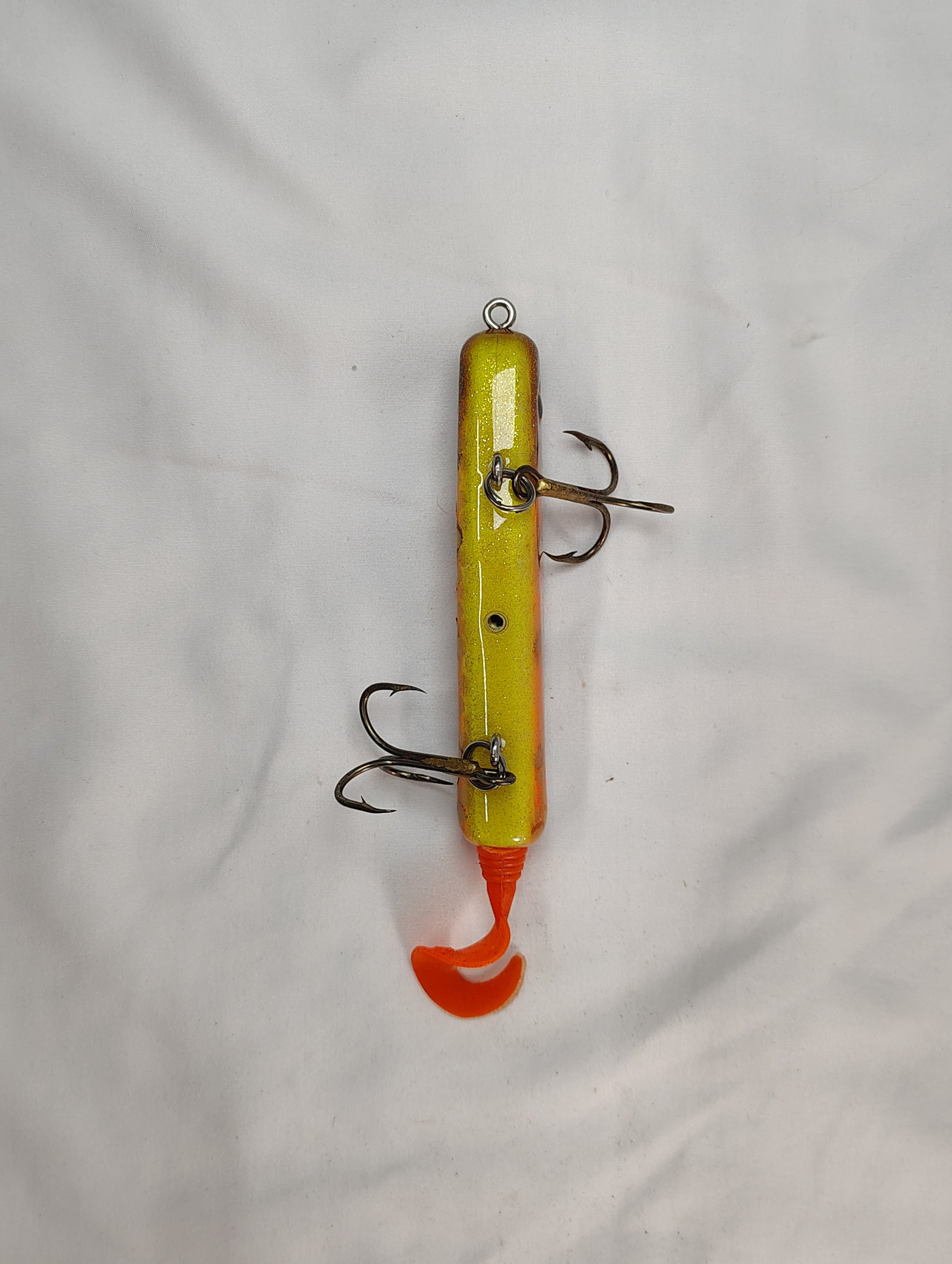 Yellow and orange fishing lure with multiple hooks on a white background