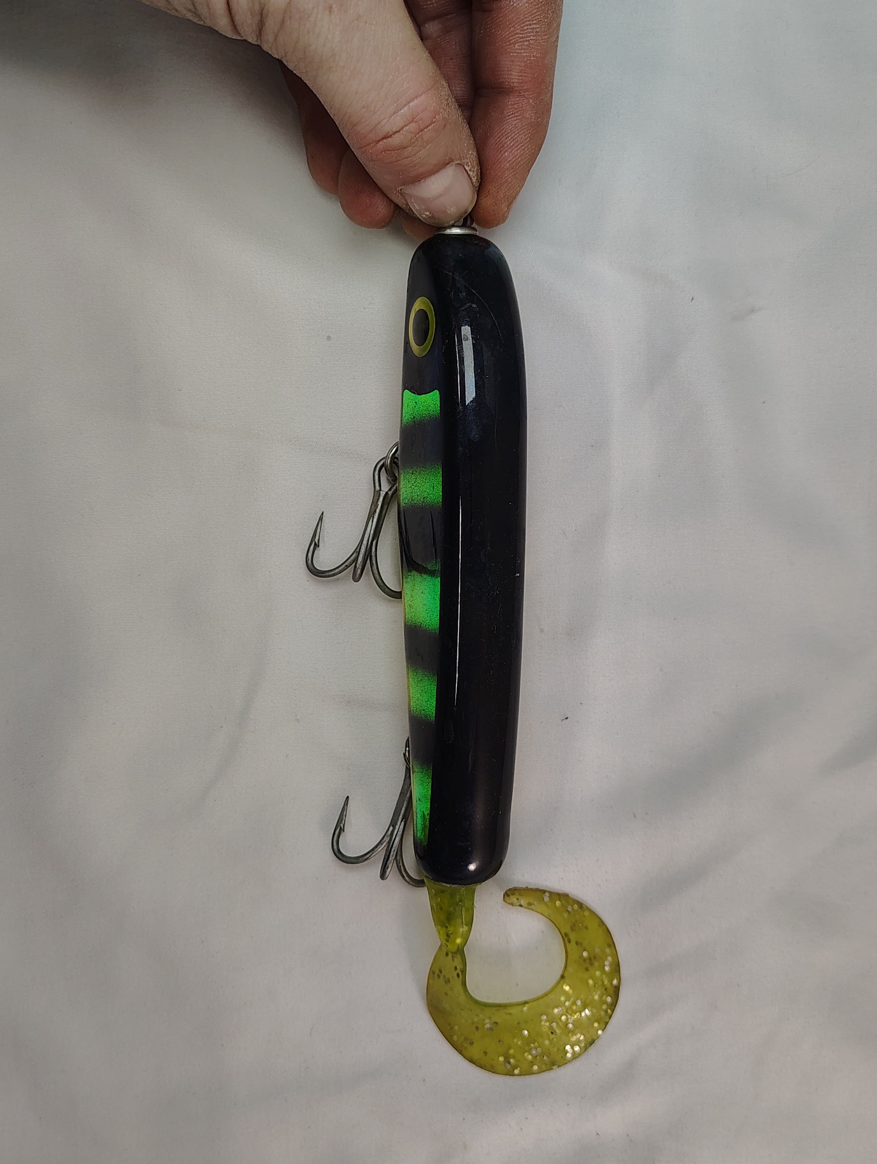 Fishing lure held by a hand on a white background