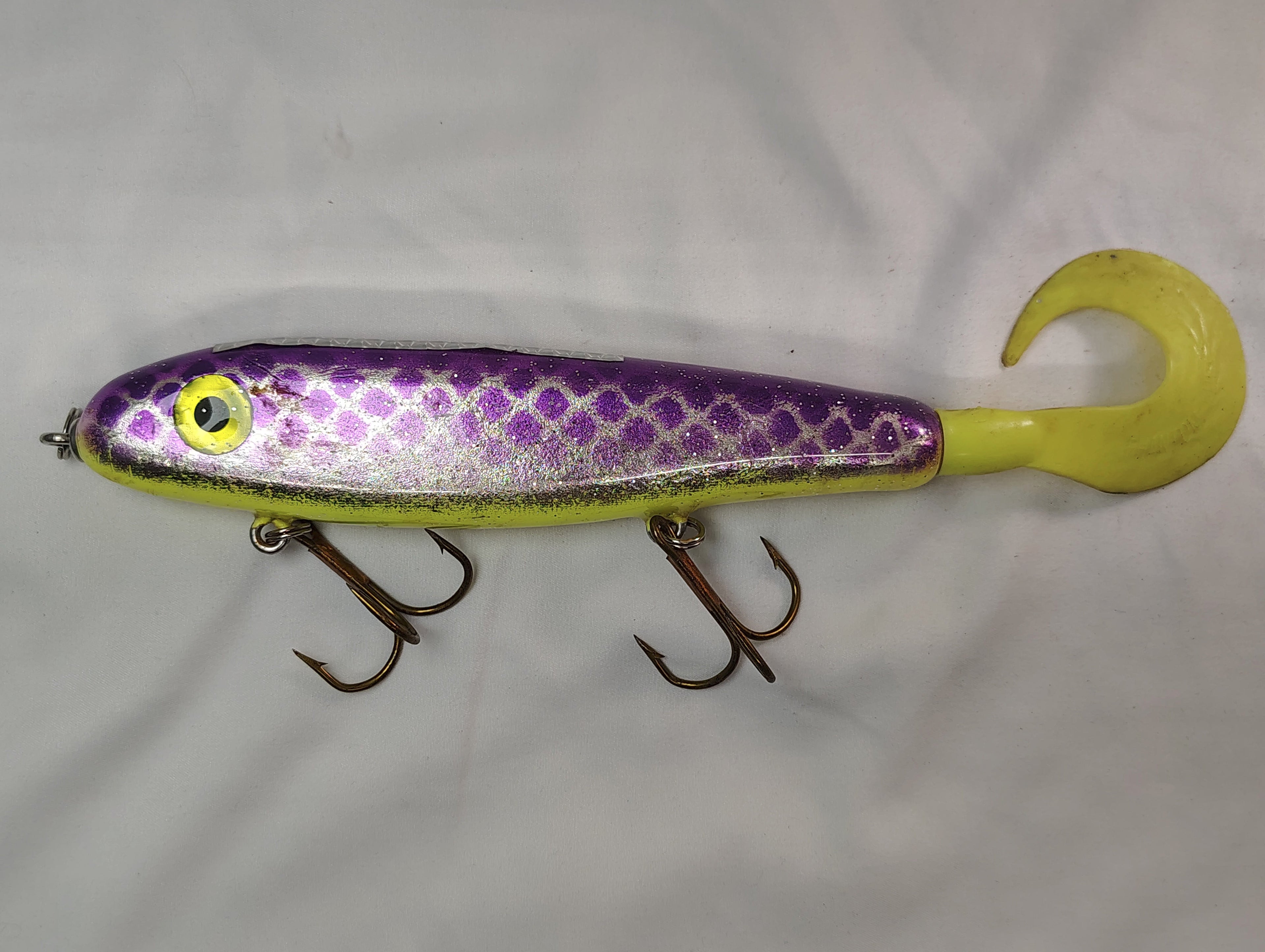 Fishing lure with purple and yellow design on a white background
