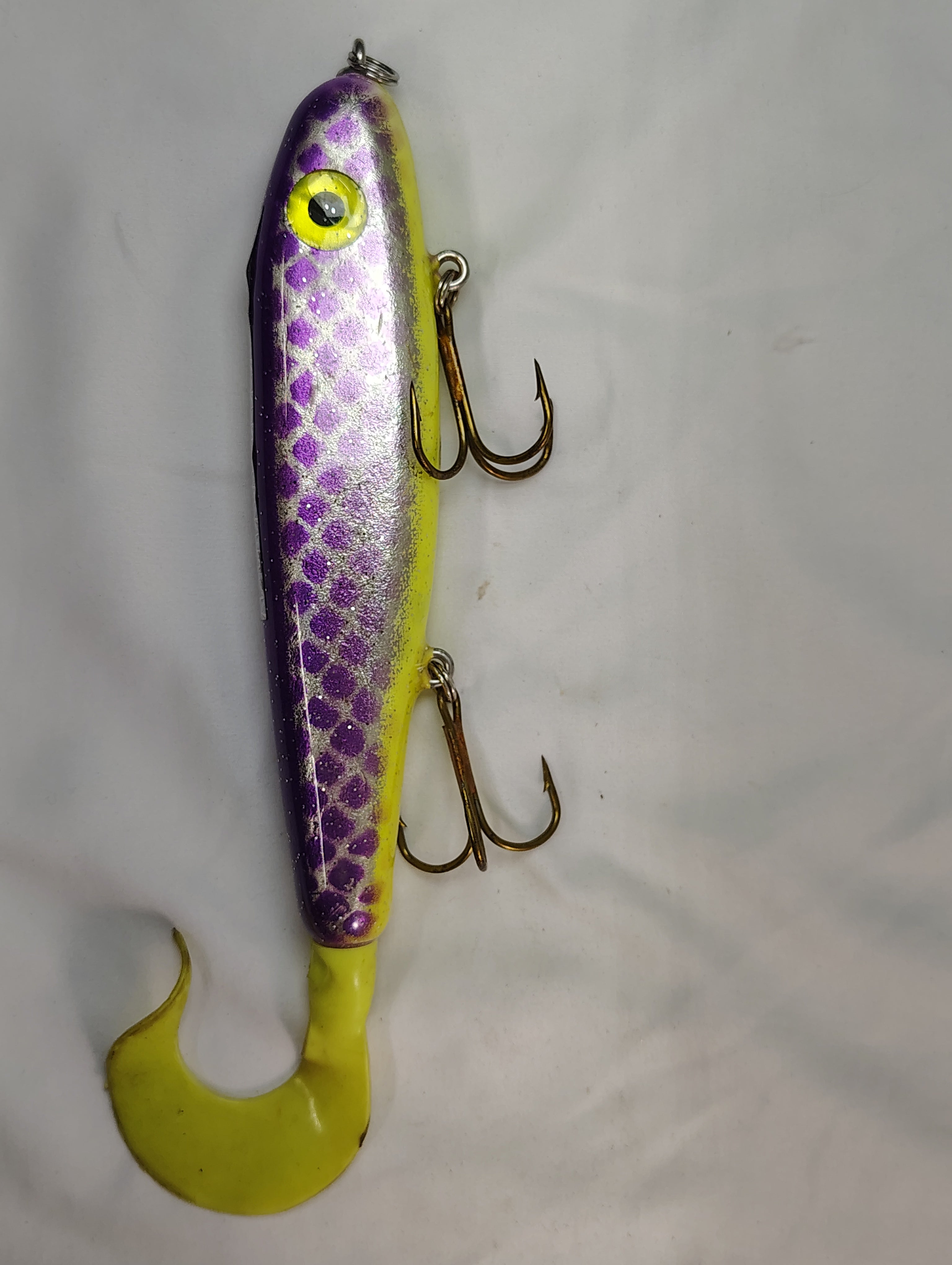 Fishing lure with purple and yellow design on a white background