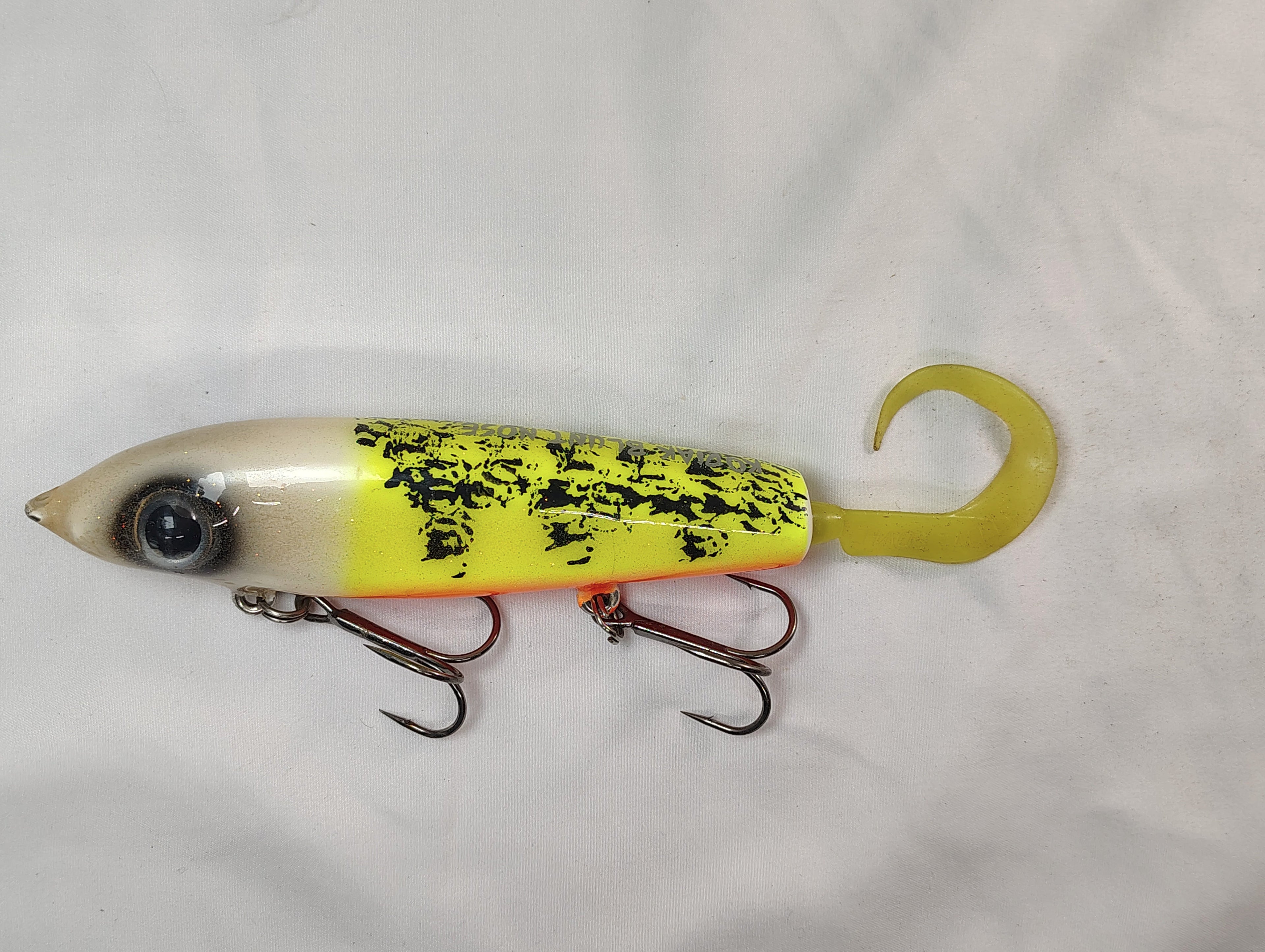 Fishing lure with yellow and black pattern on a white background