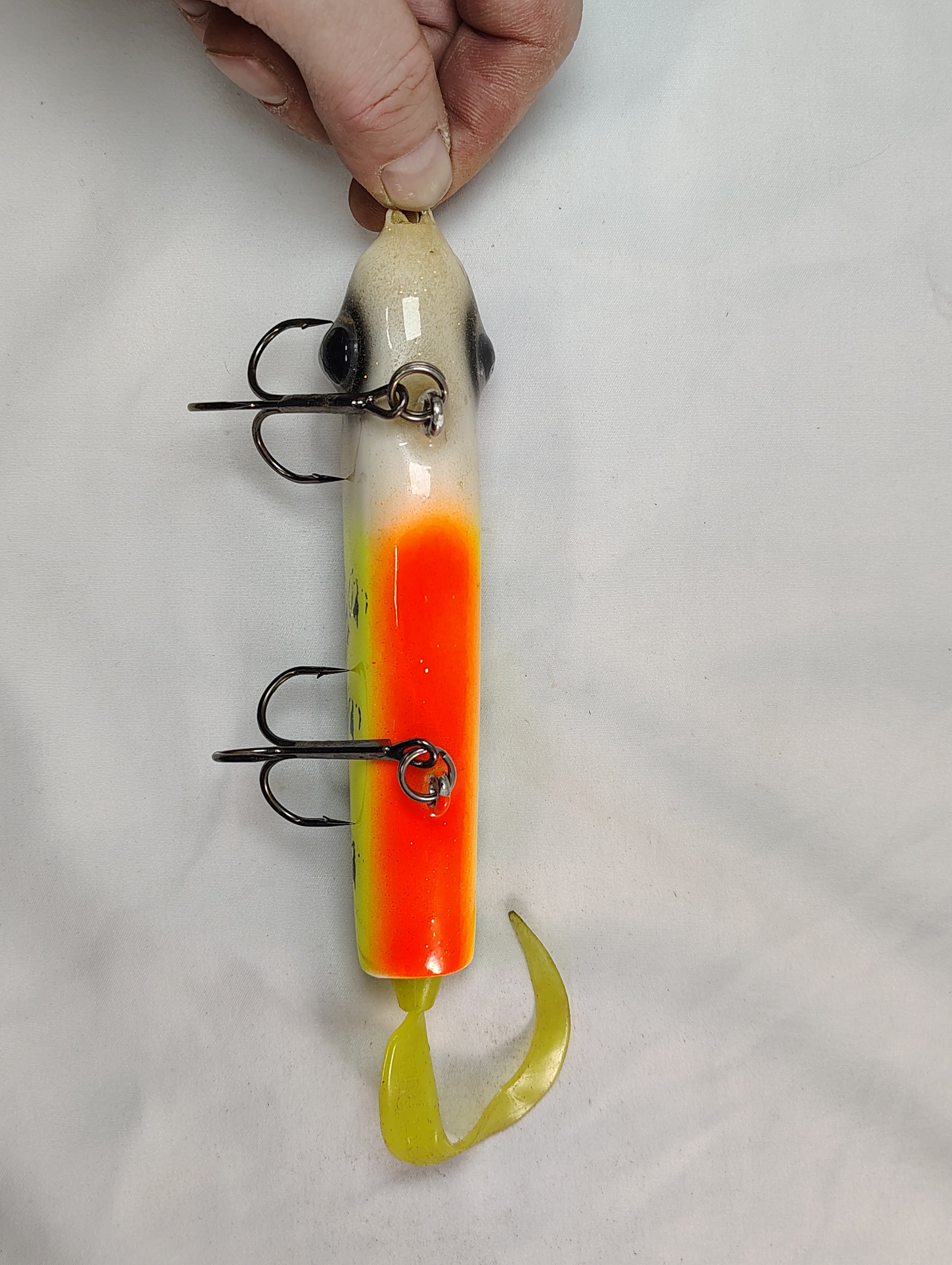 Fishing lure with a hand holding it on a white background