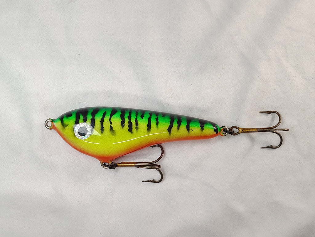 Colorful fishing lure with a striped pattern on a white background