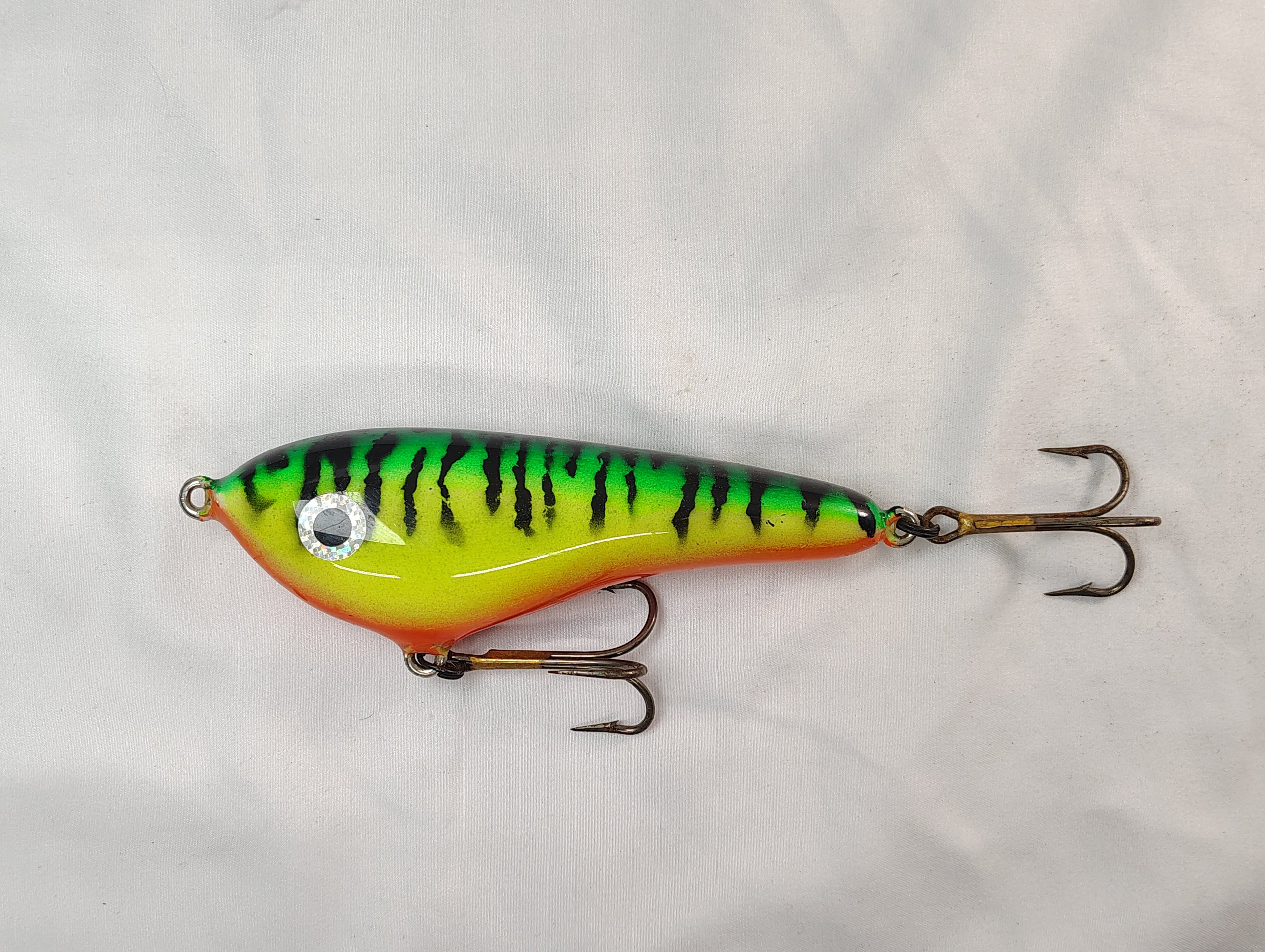 Colorful fishing lure with a striped pattern on a white background