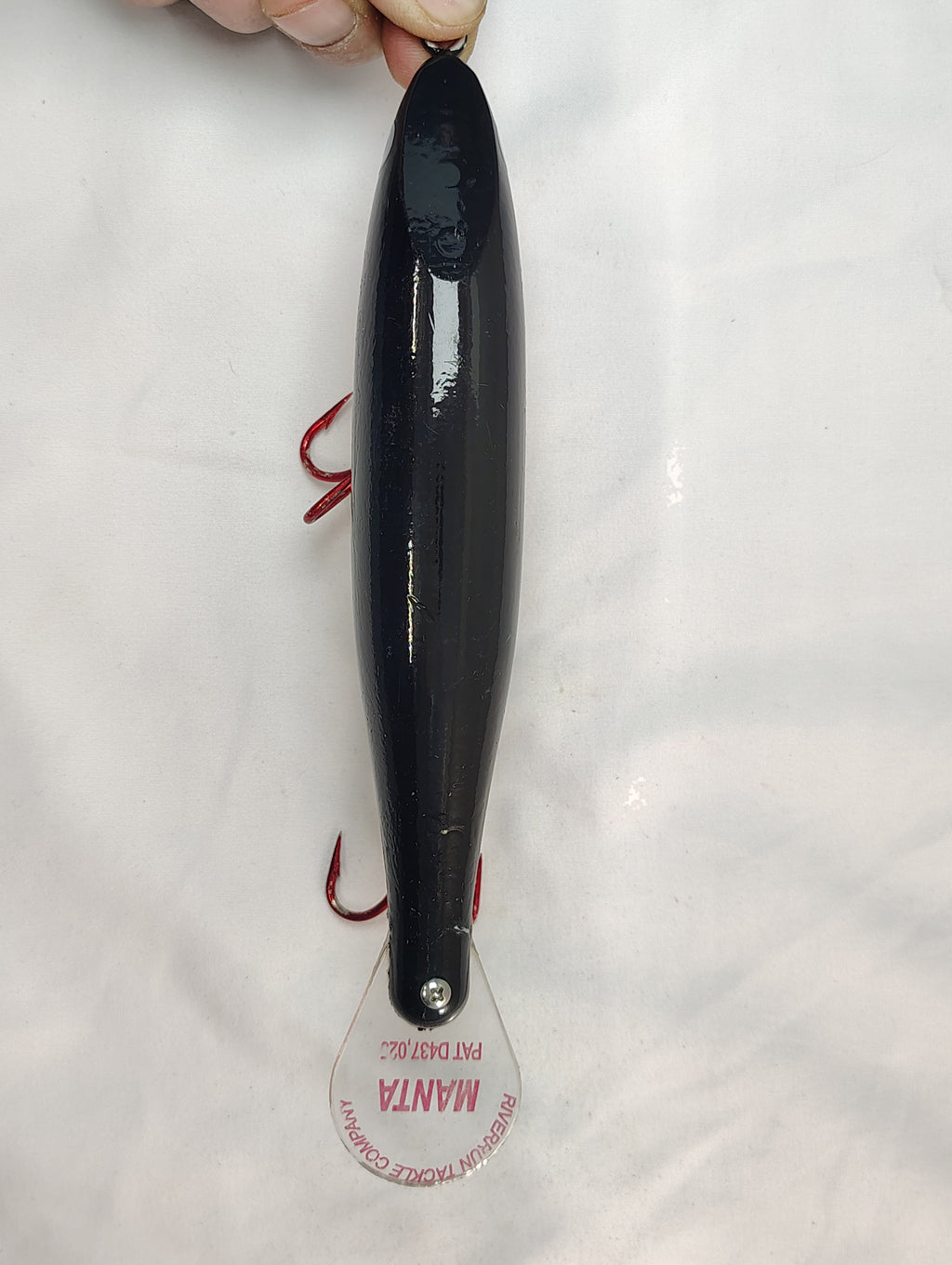 Black fishing lure with a visible brand label on a white background
