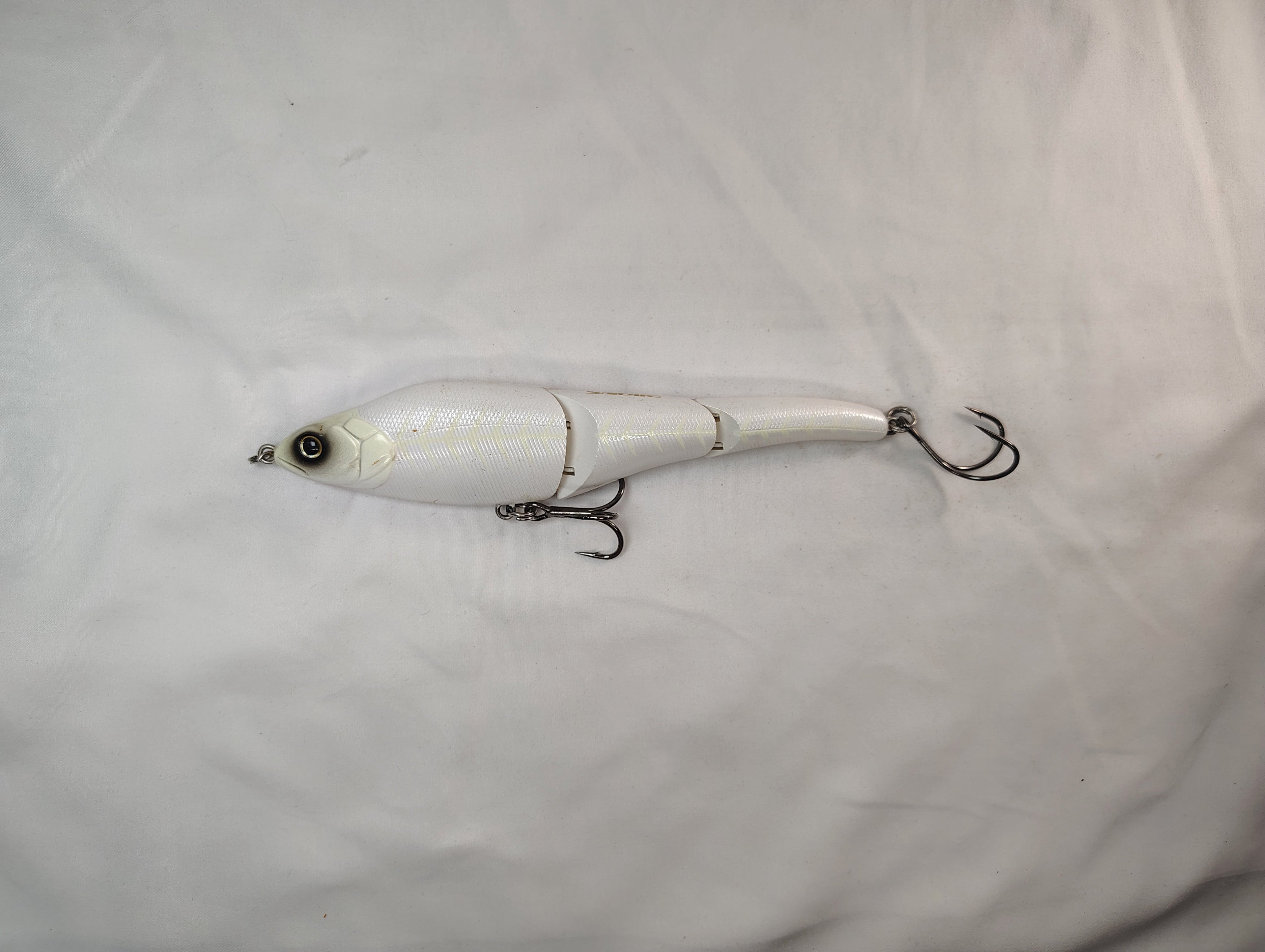 White fishing lure with a hook on a white background
