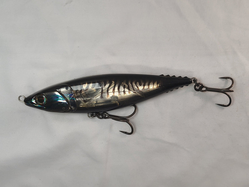 Metallic fishing lure on a white fabric background