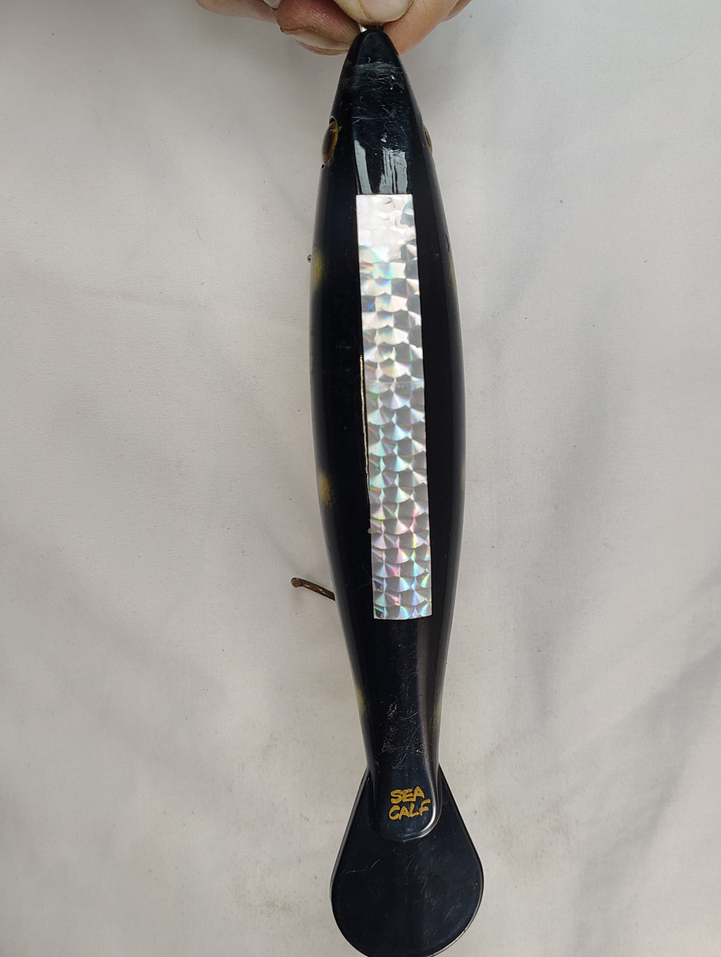 Black hairbrush with a decorative handle on a light gray background