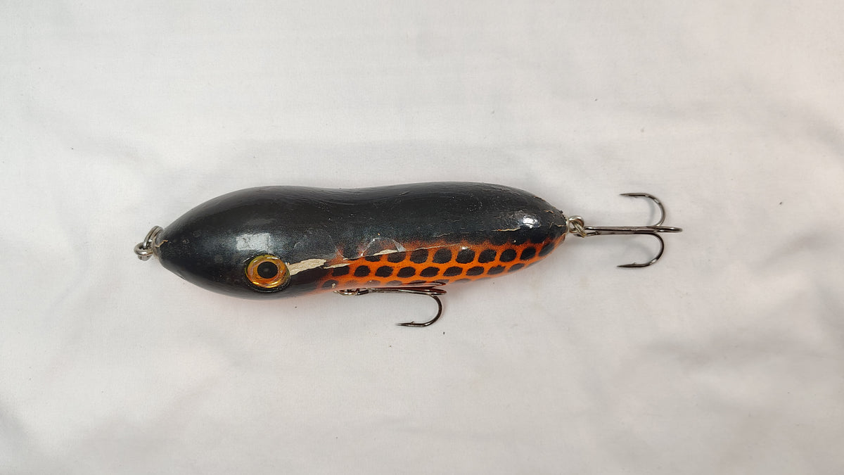 Black and orange fishing lure on a white background