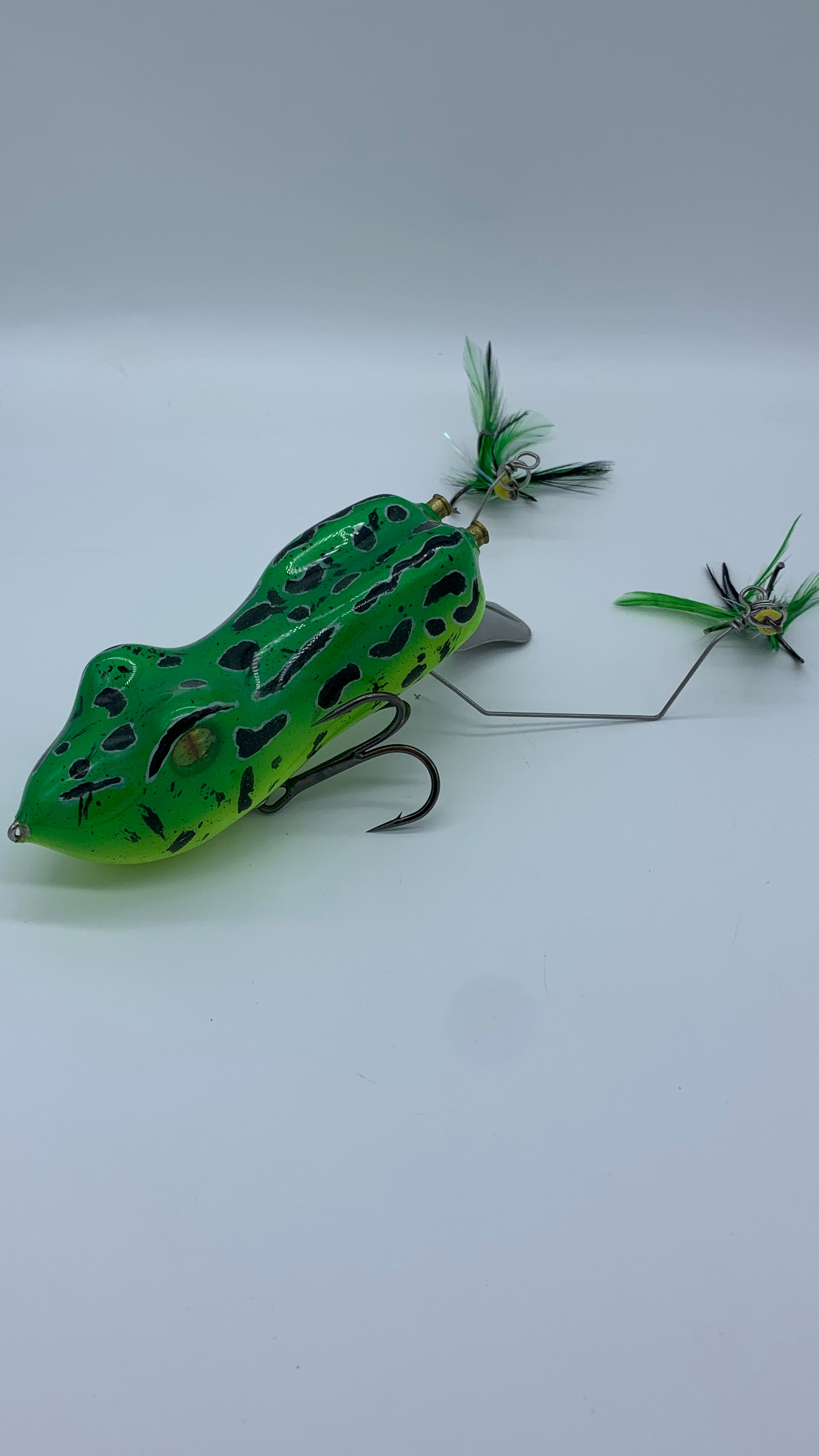 Green frog-shaped fishing lure with detailed design on a white background