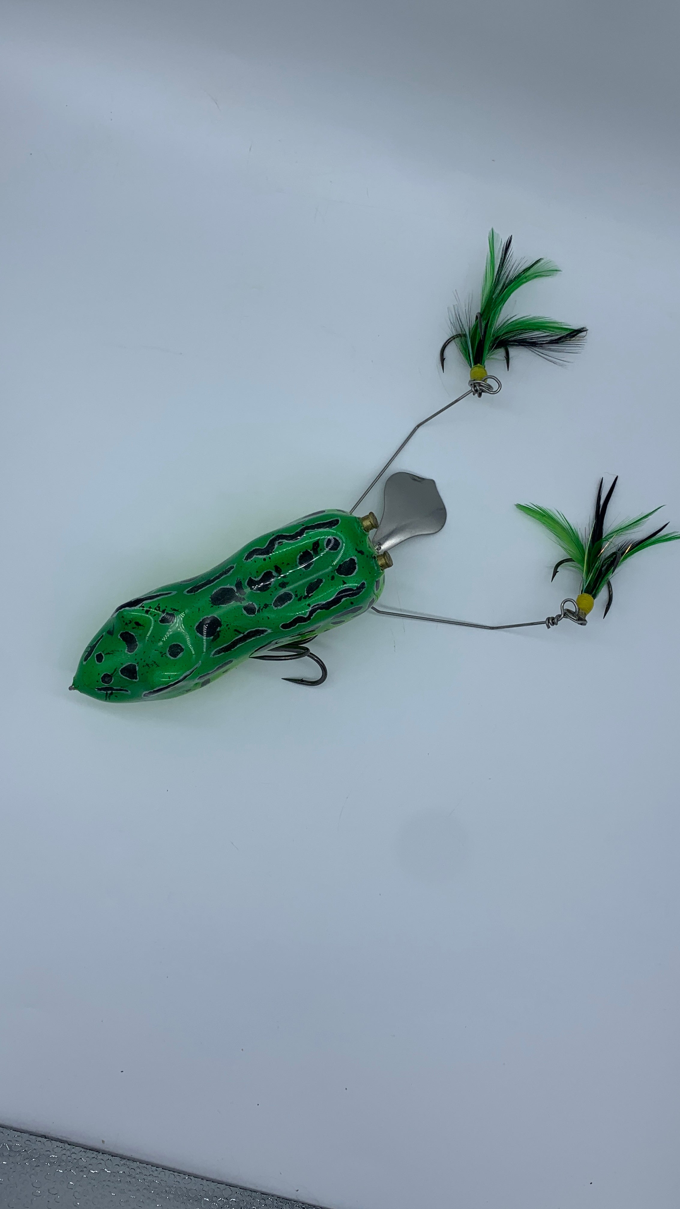 Green and black fishing lure on a white background