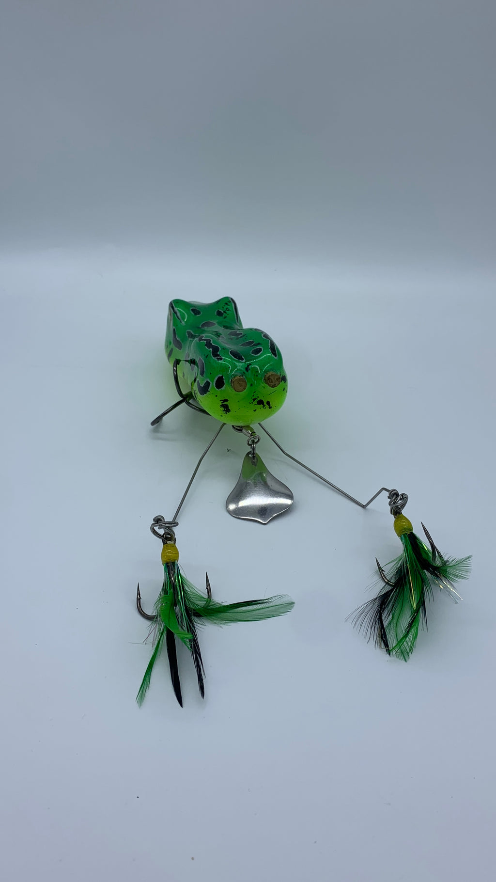 Fishing lure with green and black details on a white background