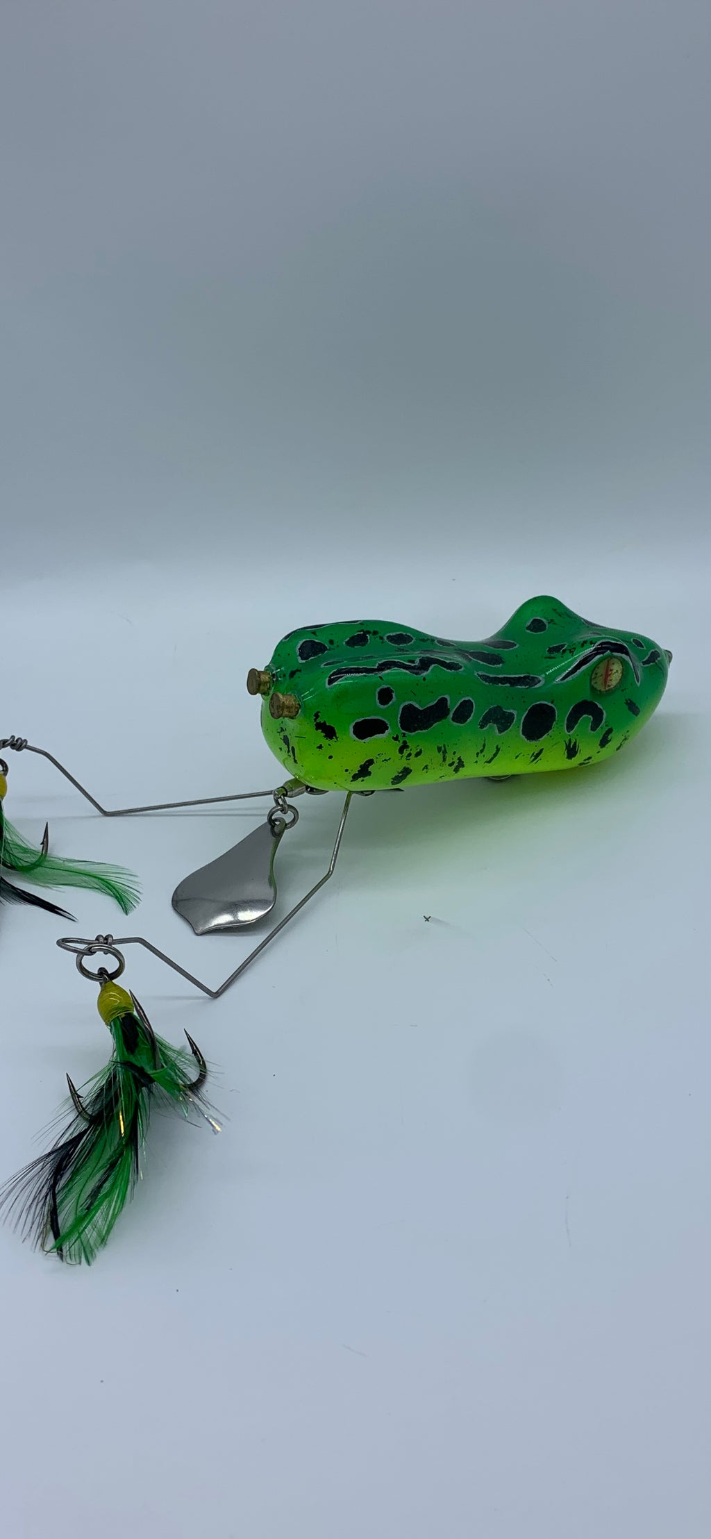 Green frog-shaped fishing lure on a white background